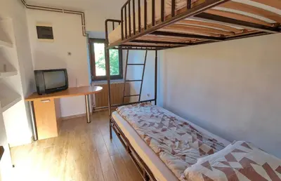 a bedroom with a bunk bed and a television at Počitniška hiša Miklavčič Primorska in Divača