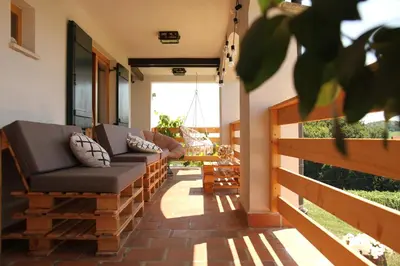 a porch with two couches on a house at Wooden fairytale in Lesično