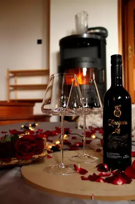 a bottle of wine and two wine glasses on a table at Wooden fairytale in Lesično