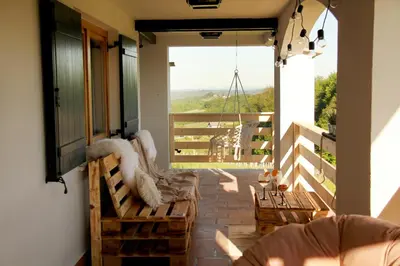 a balcony with benches and a view of the mountains at Wooden fairytale in Lesično