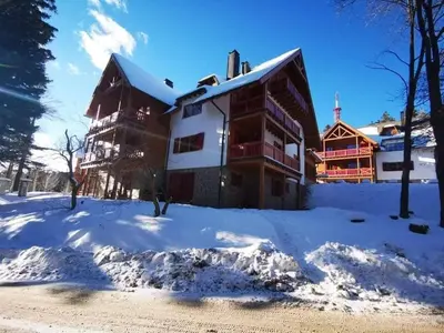 a large building with snow on the ground at Apartma Pohorje Bolfenk 5010 in Pohorje
