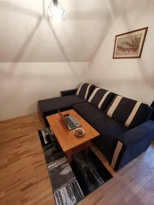 a living room with a blue couch with a wooden table at Apartma Pohorje Bolfenk 5010 in Pohorje