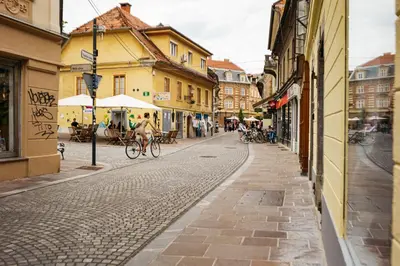 a person riding a bike down a cobblestone street at 150 steps to the main square in Ljubljana