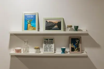 a shelf with pictures and pictures on it at 150 steps to the main square in Ljubljana