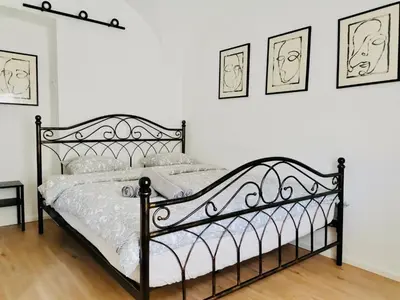 a black bed in a bedroom with three pictures on the wall at 150 steps to the main square in Ljubljana