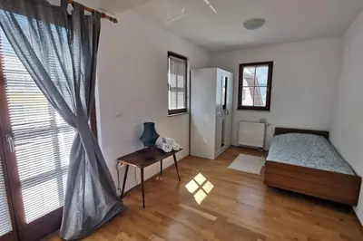 a bedroom with a bed and a table and a window at My House in Bovec