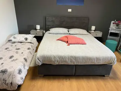 a bedroom with a bed with a red pillow on it at Apartma Ob stari murvi, Sežana in Sežana