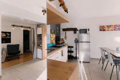 a kitchen with a refrigerator and a table with chairs at Apartma Ob stari murvi, Sežana in Sežana