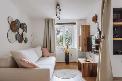 a living room with a white couch and a window at Apartma Ob stari murvi, Sežana in Sežana