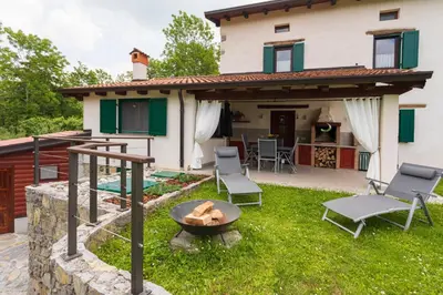 a patio with a fire pit in front of a house at Tinčeva hiša in Kanal