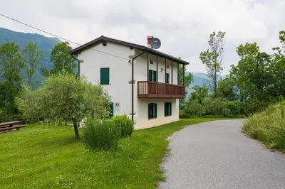 a house with a balcony on the side of a road at Tinčeva hiša in Kanal