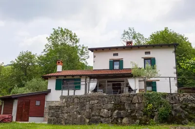 an old house with a stone wall at Tinčeva hiša in Kanal