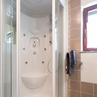 a bathroom with a shower and a sink at Tinčeva hiša in Kanal