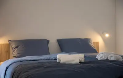 a bed with two stuffed animals sitting on it at Apartments Aura in Deskle