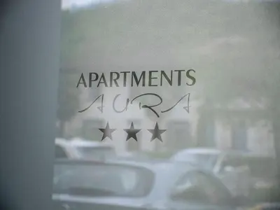 a sign on a window with cars in the street at Apartments Aura in Deskle