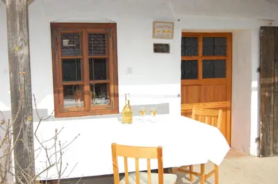 a white table with a bottle of wine on it at Balajceva domačija - Moravske Toplice in Moravske Toplice