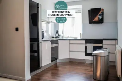 a kitchen with a refrigerator and a trash can at Celje Center Apartment in Celje