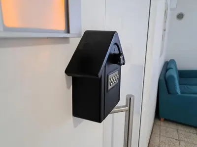 a black box on a wall next to a blue chair at Celje Center Apartment in Celje
