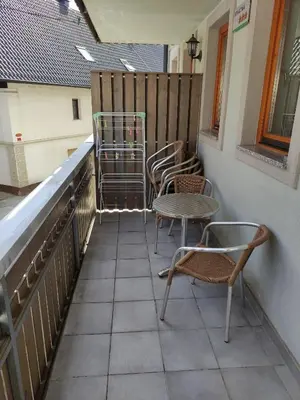 three chairs and a table on a balcony at Apartments Bohinjc in Bohinj