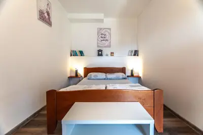 a small bedroom with a bed and a table at Apartments JULIA Bohinj in Bohinj