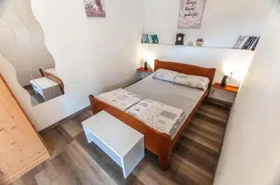 a small bedroom with a bed and a small table at Apartments JULIA Bohinj in Bohinj