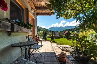 a patio with a table and chairs and a view at Apartments JULIA Bohinj in Bohinj
