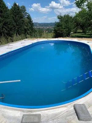 a large blue swimming pool in a backyard at Hillside Bio Glamping in Prebold