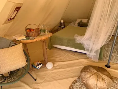 a room with a tent with a table and a chair at Hillside Bio Glamping in Prebold