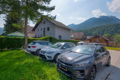 three cars parked in a parking lot in front of a house at Pri Marusi in Kranjska Gora