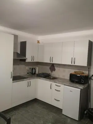 a kitchen with white cabinets and a microwave at Apartma Juteršek 2+2 in Libeliče