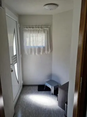 a small room with a window and a blue stool at Apartma Juteršek 2+2 in Libeliče