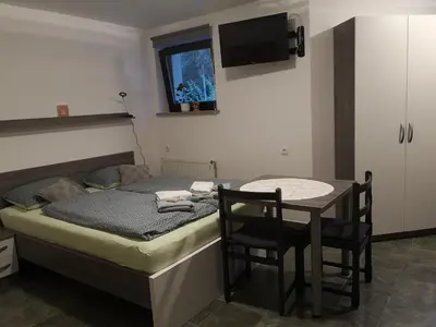 a bedroom with a bed and a table with chairs at Apartma Juteršek 2+2 in Libeliče