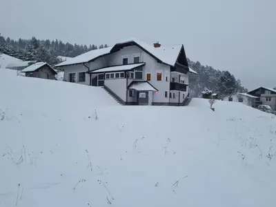 a house on a hill covered in snow at Apartma Juteršek 2+2 in Libeliče