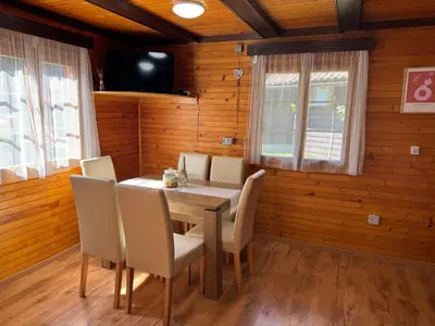 a wooden dining room with a table and chairs at Teddy in Čatež ob Savi