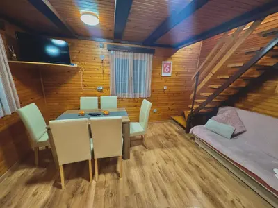 a dining room with a table and chairs and a couch at Teddy in Čatež ob Savi