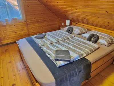 a bed in a wooden room with a wooden floor at Teddy in Čatež ob Savi