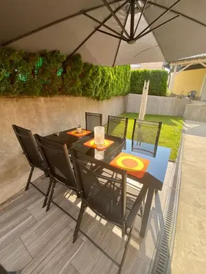 a table and chairs under an umbrella on a patio at Jack's Place in Trbovlje
