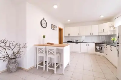 a kitchen with white cabinets and a table in it at House Eden with Mountain Views in Bled