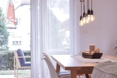 a dining room with a table and a window at House Eden with Mountain Views in Bled