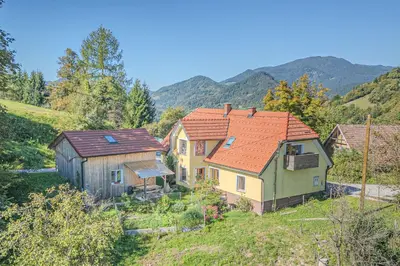 a group of houses with mountains in the background at Farmhouse Blackberry Pool & Wellness- Happy Rentals in Vransko