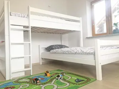 a bedroom with bunk beds and a toy train rug at Apartment Vida in Bled