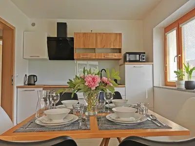 a dining room table with a vase of flowers on it at Apartment Vida in Bled