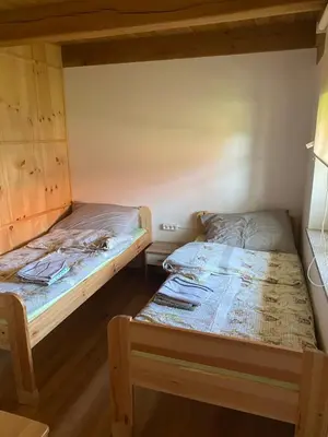 two beds in a small room with one bedskirtsermottermott at Domačija Brdar in Adlešiči