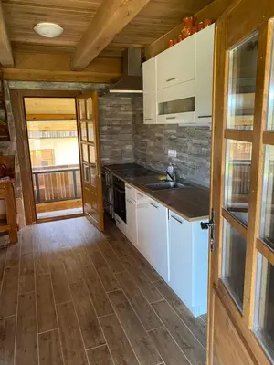 a kitchen with white appliances and a wooden ceiling at Domačija Brdar in Adlešiči