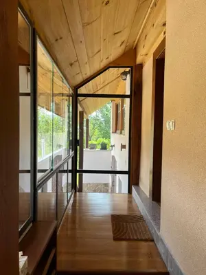 a hallway of a house with wooden ceilings and glass doors at Domačija Brdar in Adlešiči