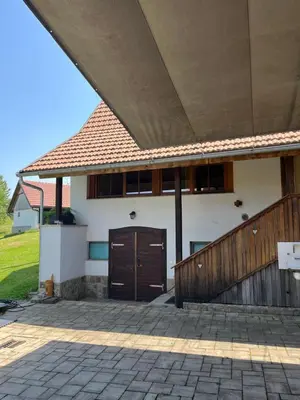 a house with a brown door and a wooden fence at Domačija Brdar in Adlešiči