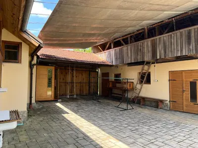 a patio with a roof and a ladder on a building at Domačija Brdar in Adlešiči