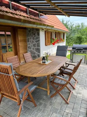 a wooden table and chairs on a patio at Domačija Brdar in Adlešiči