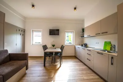 a kitchen with a table and chairs and a couch at Apartmaji Prton Bovec in Bovec