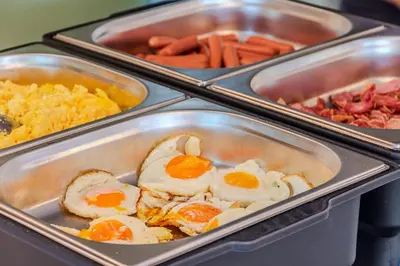 a buffet with eggs and other food in trays at Penzion Hosnar, Apartment Mišc in Bovec